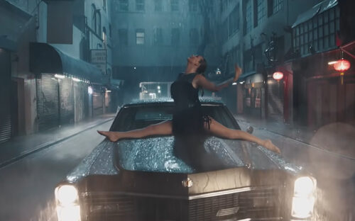 Taylor Swift in the splits on the hood of a 1967 Cadillac Fleetwood 60 Special