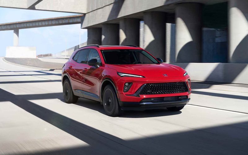 Red 2026 Buick Envision driving down the road.