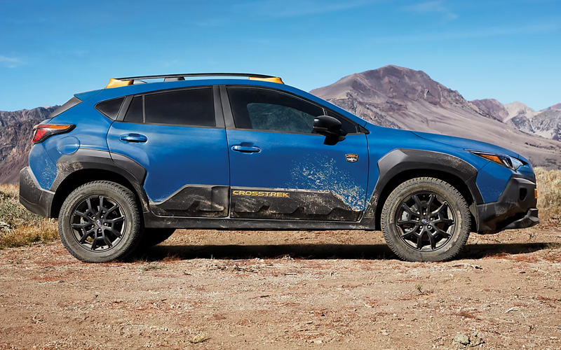 A blue 2026 Subaru Crosstrek parked on a dirt road in the middle of nowhere