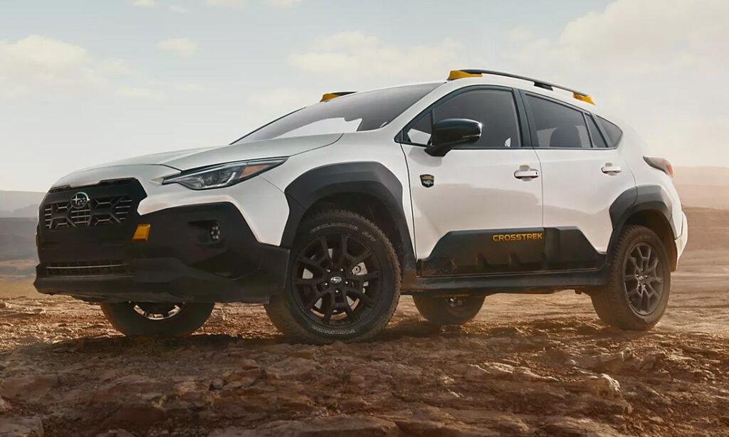 A white 2026 Subaru Crosstrek hybrid parked on a dirt road in the middle of nowhere