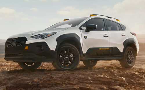 A white 2026 Subaru Crosstrek hybrid parked on a dirt road in the middle of nowhere