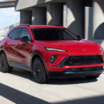 Red 2026 Buick Envision driving on the road