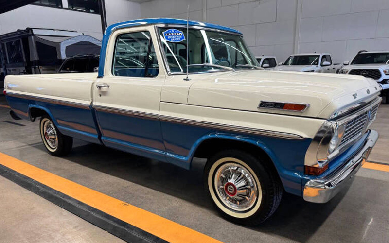 1970 Ford F-100 A blue and white two-tone 1970 Ford F-100 in a garage.