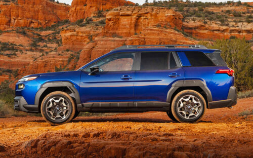 A blue 2026 Subaru Outback sitting in the desert near dusk