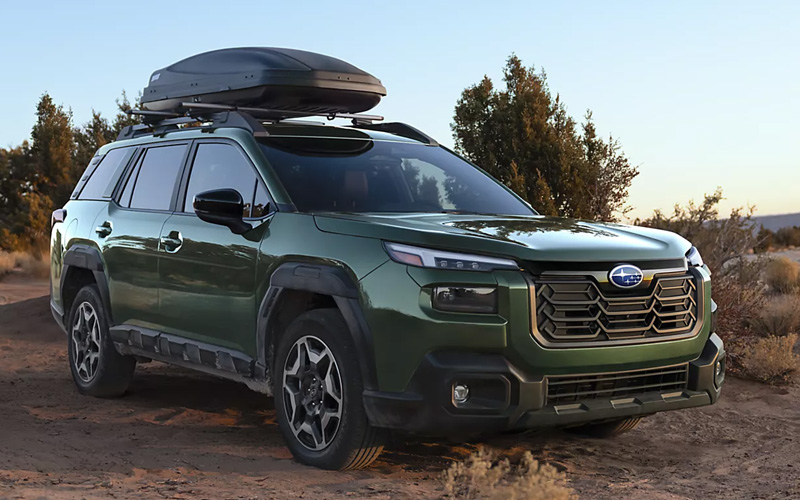 A dark green 2026 Subaru Outback off road in a rural setting