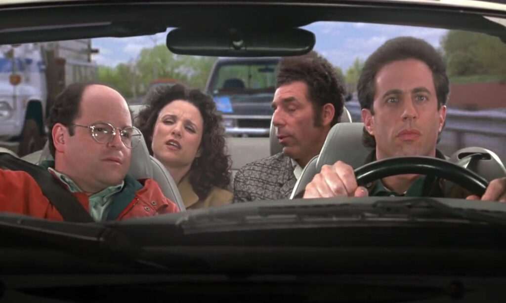 Jerry, George, Elaine, and Kramer sitting in a vehicle on the show Seinfeld.