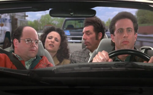 Jerry, George, Elaine, and Kramer sitting in a vehicle on the show Seinfeld.