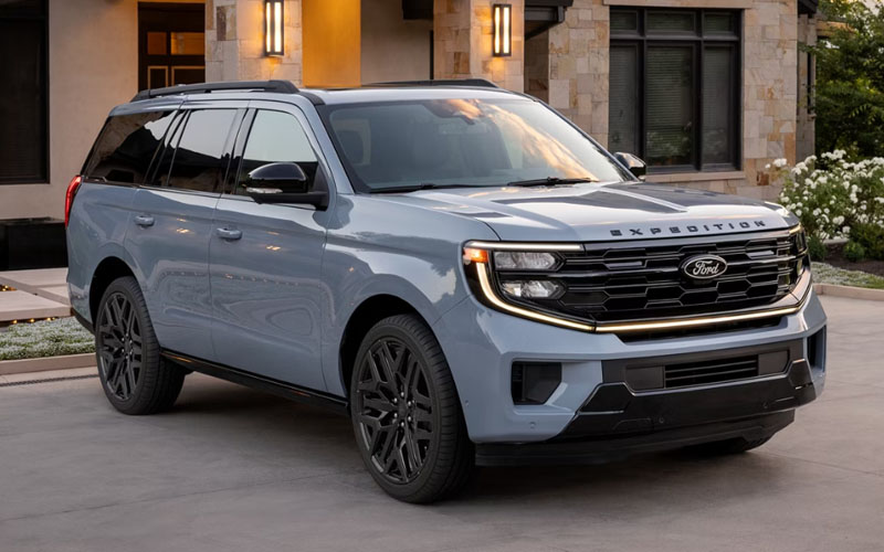A gray-blue 2026 Ford Expedition parked in the driveway of a nice home.