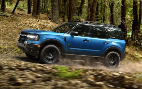 Blue 2026 Ford Bronco Sport driving through a wooded area