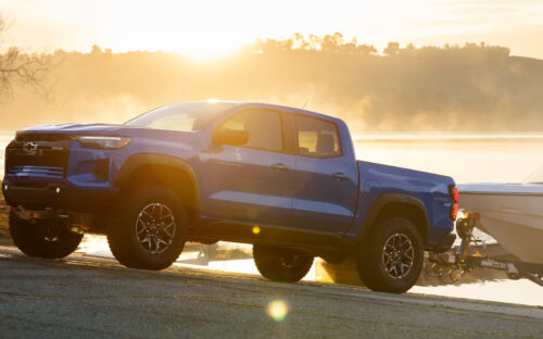 A blue 2026 Chevy Colorado towing a boat out of the lake on a boat ramp