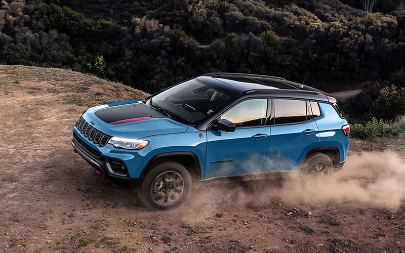 Blue 2026 Jeep Compass Driving on Dusty Path