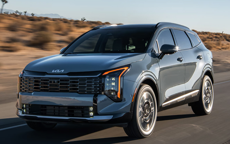 2026 Kia Sportage Hybrid A blue-gray 2026 Kia Sportage Hybrid in motion on a highway.