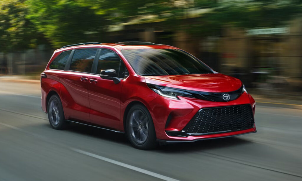 A red 2026 Toyota Sienna in motion on a city street