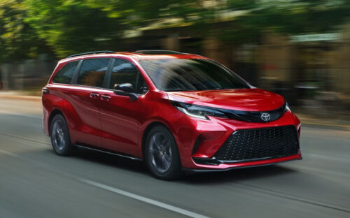 A red 2026 Toyota Sienna in motion on a city street