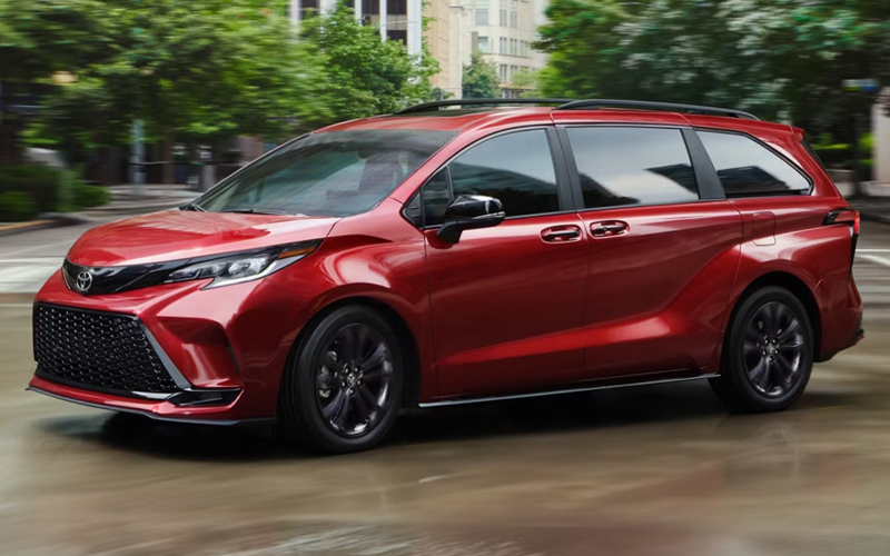 A red 2026 Toyota Sienna in motion on a city street