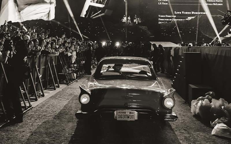 SC_1950_Ford_Thunderbird Black and White photo of Sabrina Carpenter driving a 1950s Ford Thunderbird off her Coachella set