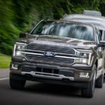 A 2026 Ford F-150 hauling a trailer down a two-lane highway.